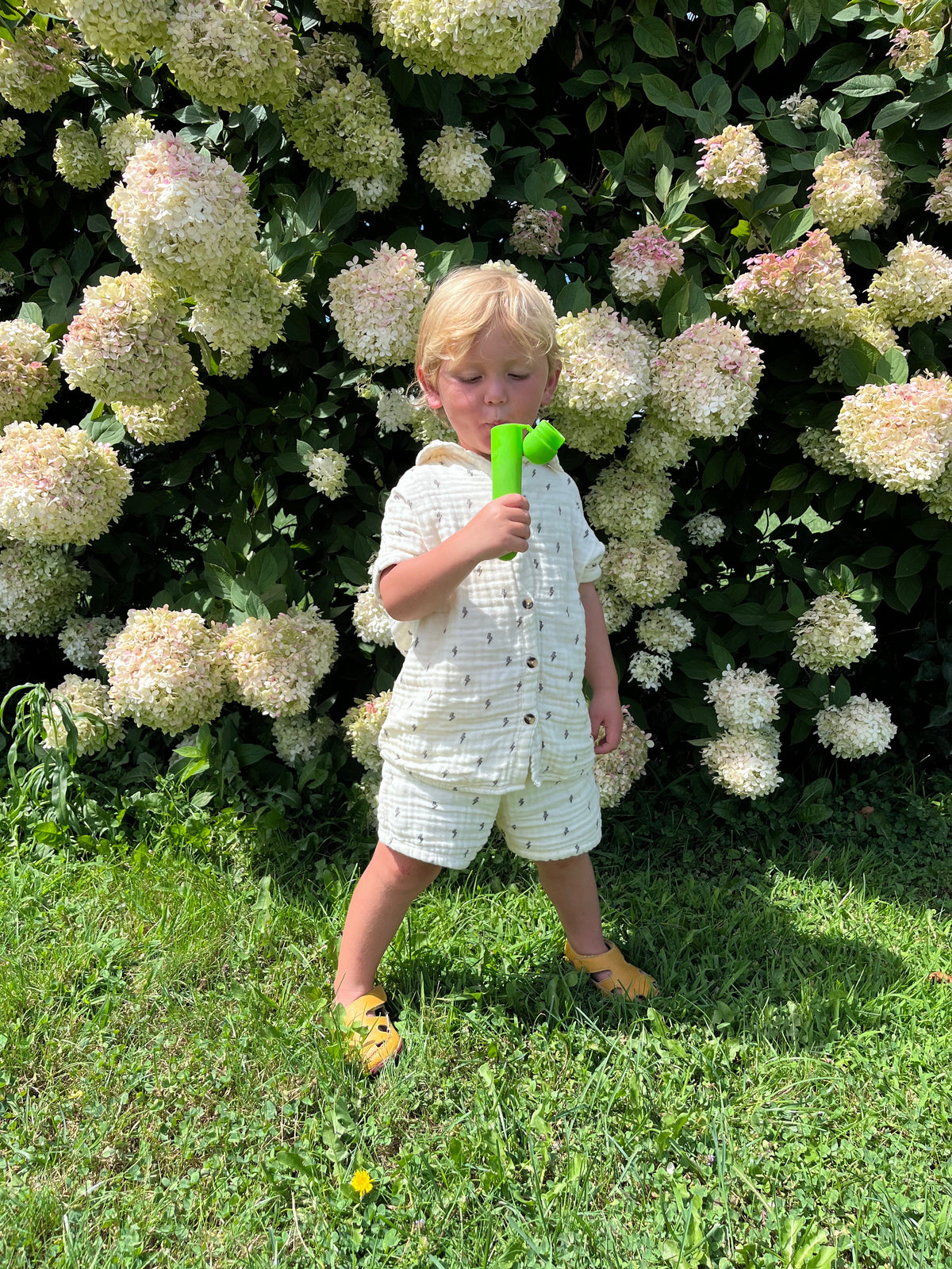 child enjoying a cucumber tulsi lime herbal electrolyte popsicle made by town farm tonics