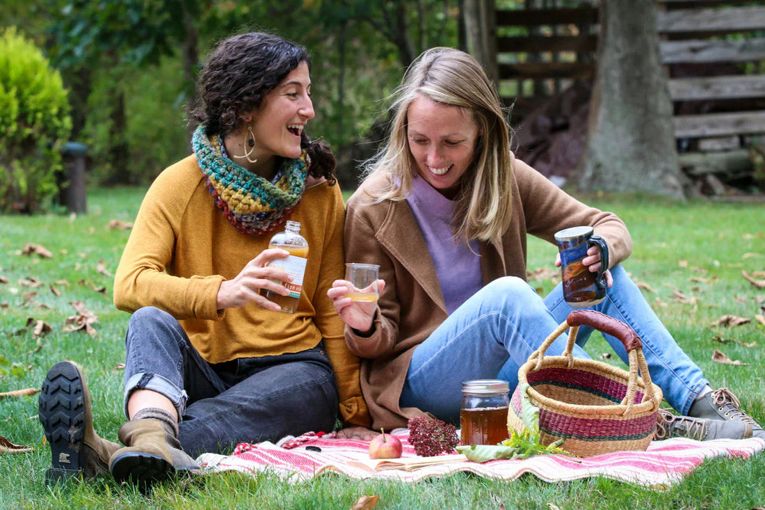 Two women enjoying Fire Cider Margarita at a picnic