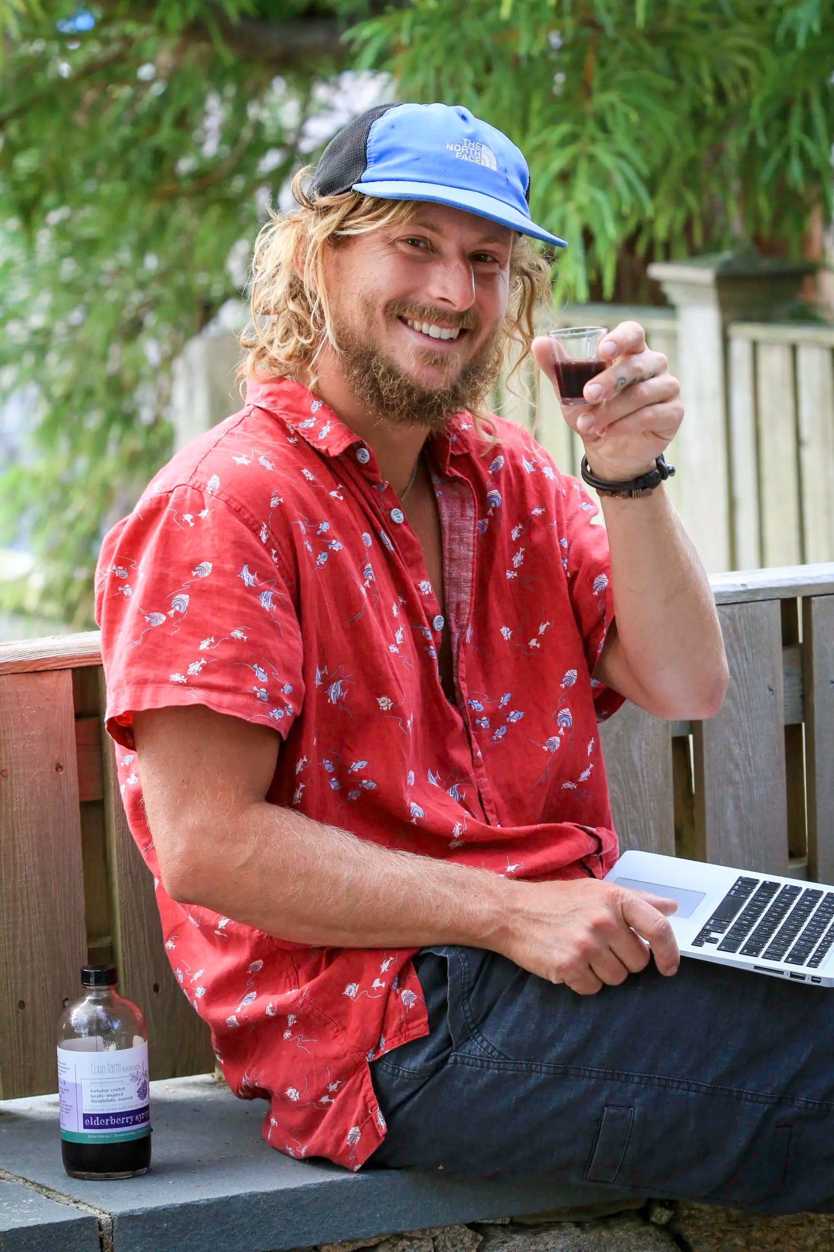 Man drinking elderberry tonic outside