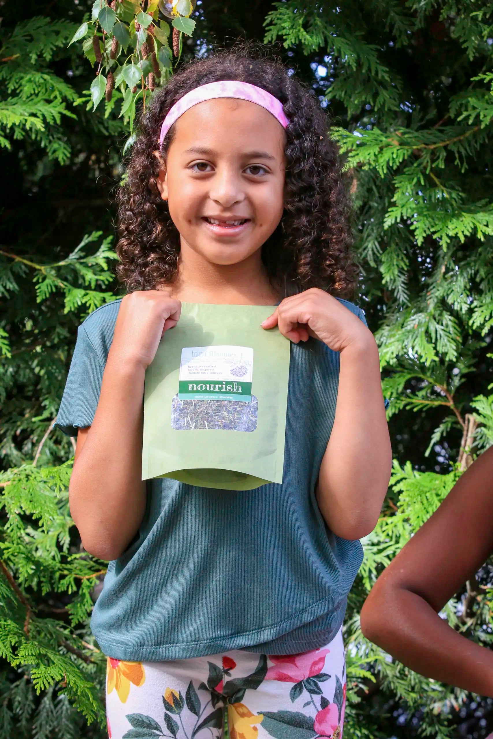 Little girl holding nourish packaged product