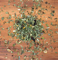 Herbs for tonics laid out on wood background