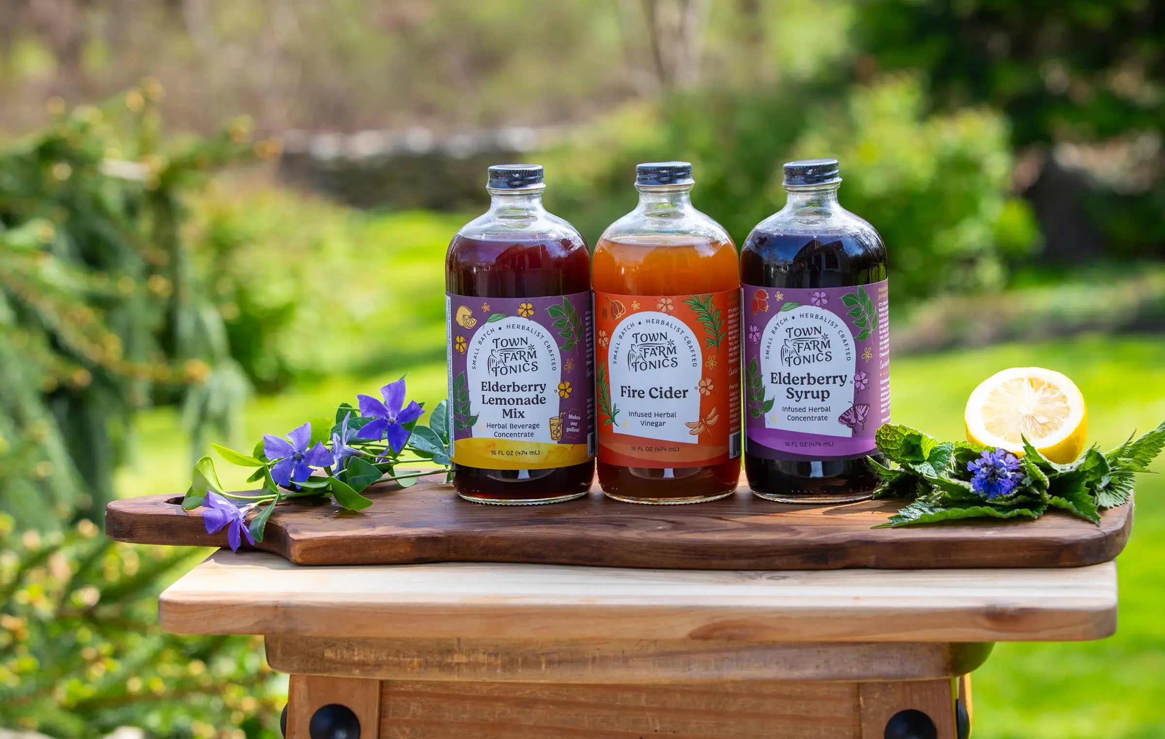 Three bottles of different syrups on a wooden board with a natural background