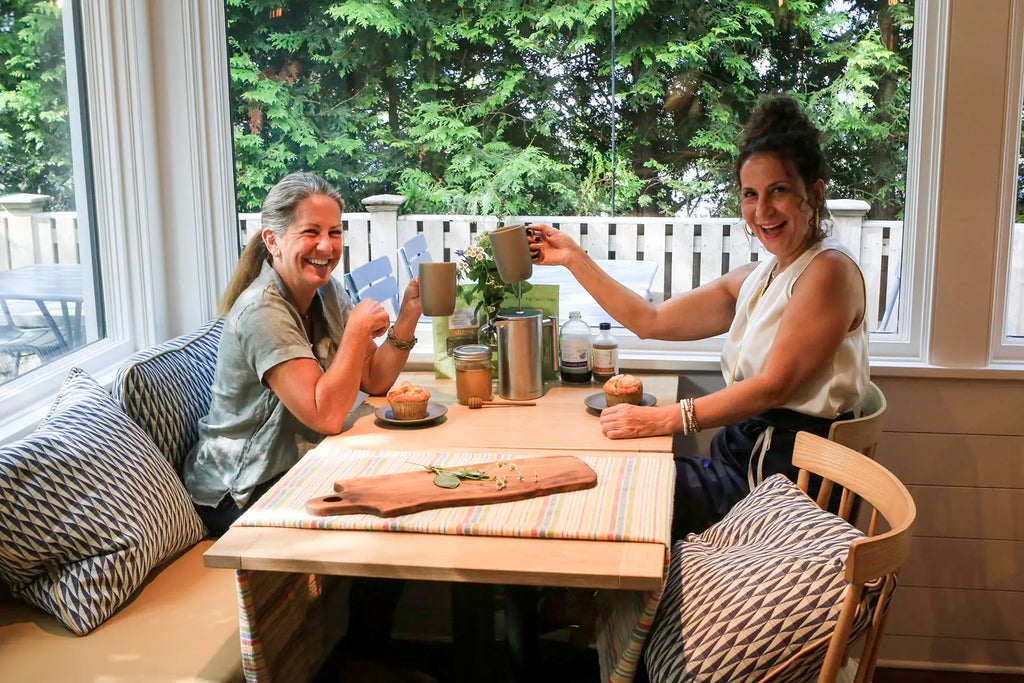 Two women sitting at a table drinking the tonics