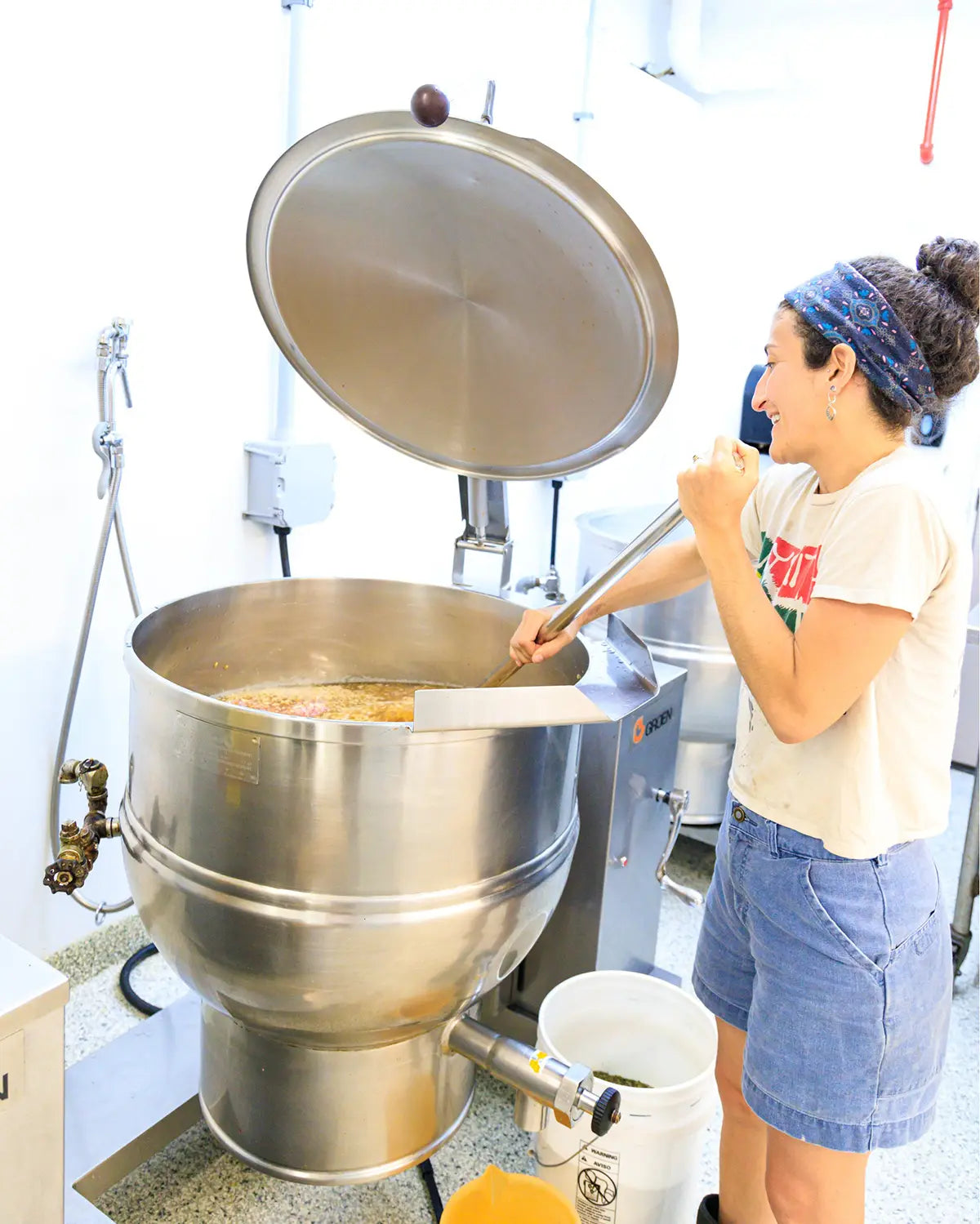 Owner operating a large metal cooking machine in a kitchen setting